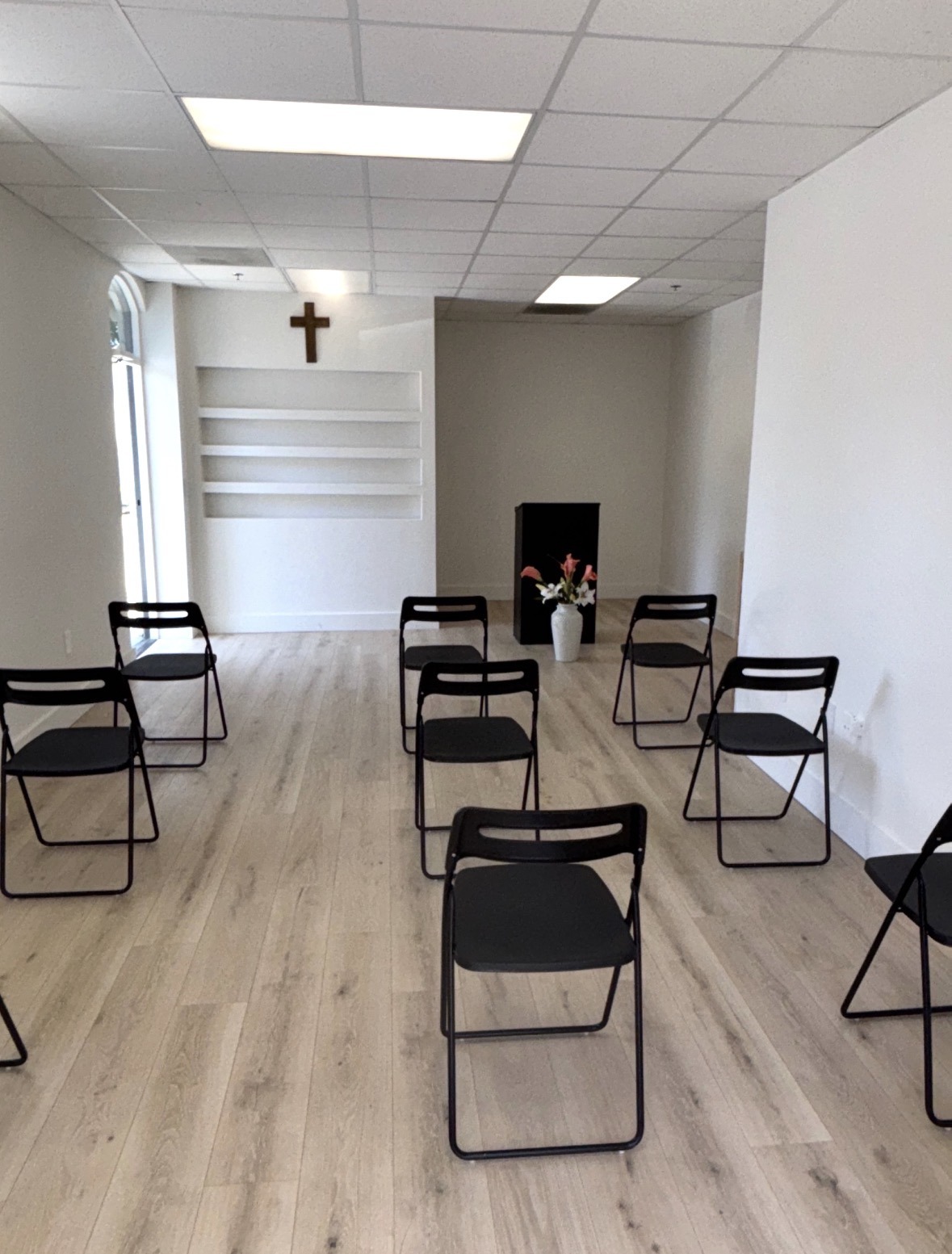 A sanctuary room featuring chairs arranged around a wall with a prominent cross.