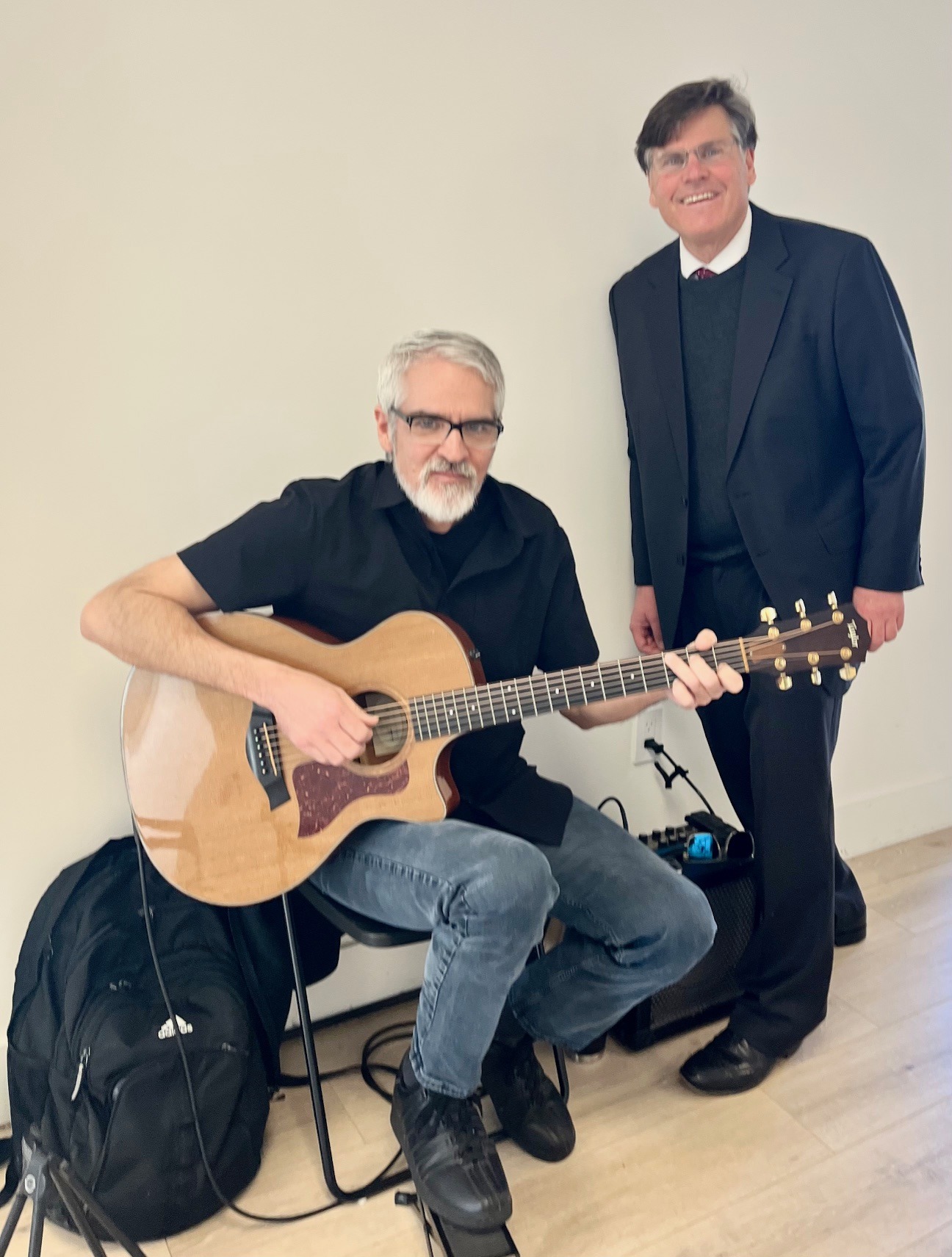 Brian Mayo and another man pose together with guitars, both smiling for the photo